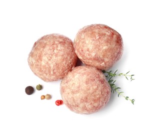 Three fresh raw meatballs with thyme and spices on white background, top view