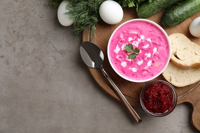 Photo of Delicious cold summer beet soup on grey table, flat lay. Space for text
