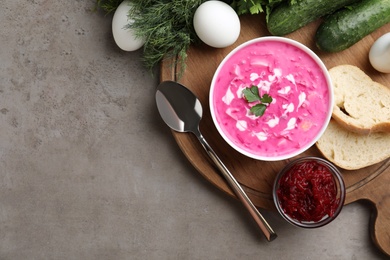 Delicious cold summer beet soup on grey table, flat lay. Space for text