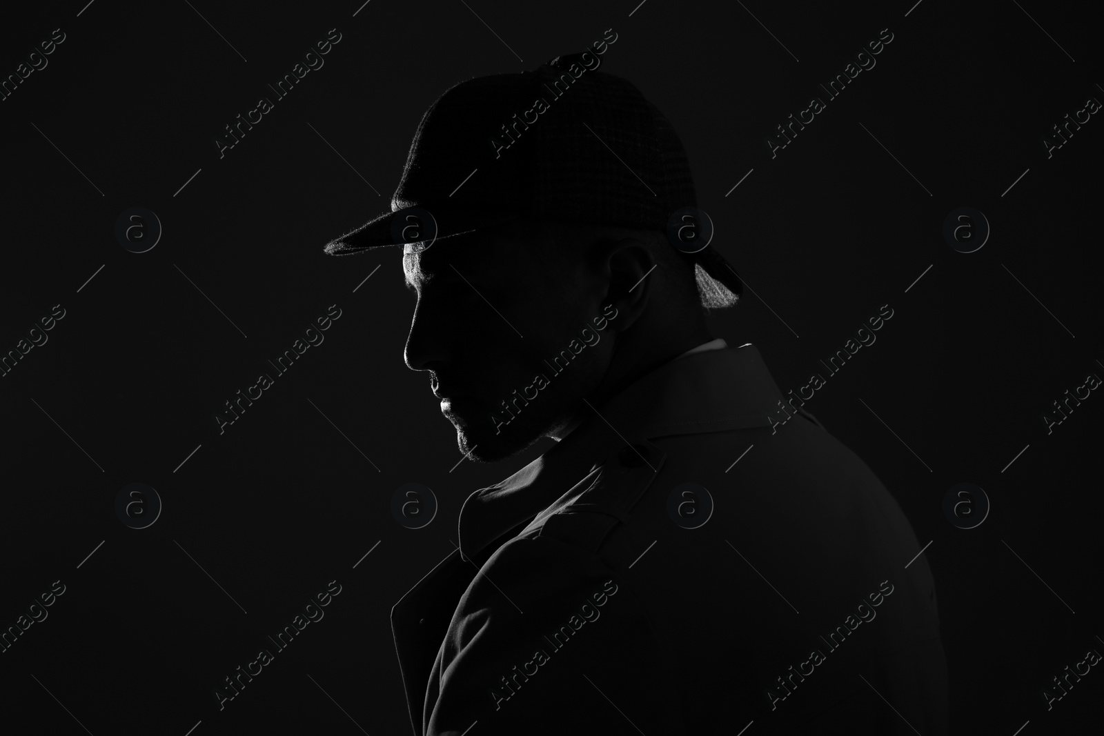 Photo of Old fashioned detective in hat on dark background, black and white effect. Space for text