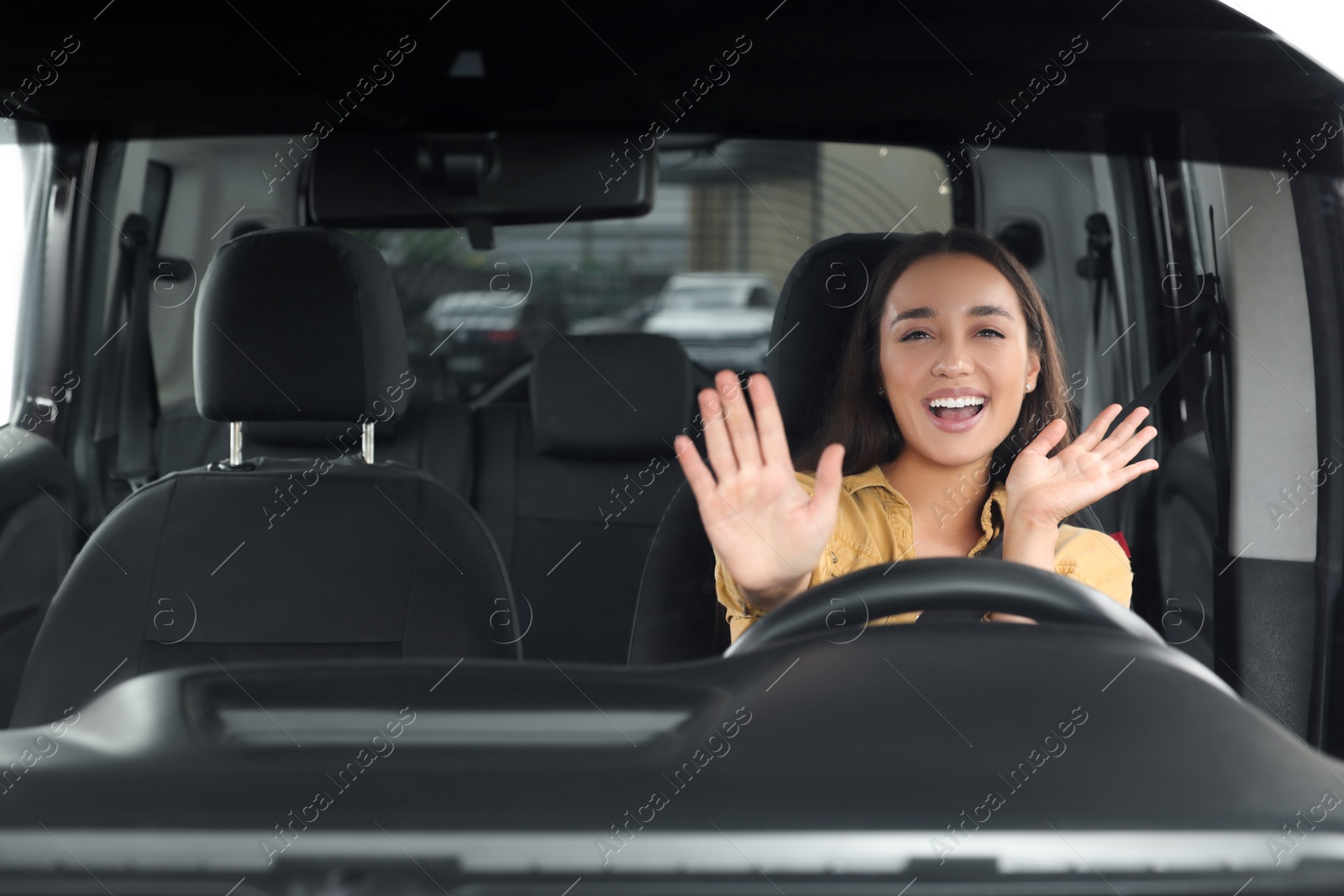 Photo of Listening to radio. Beautiful woman enjoying music in car, view through windshield