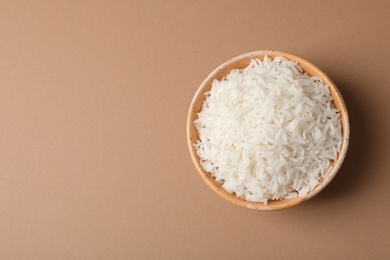 Photo of Bowl of tasty cooked rice on color background, top view. Space for text