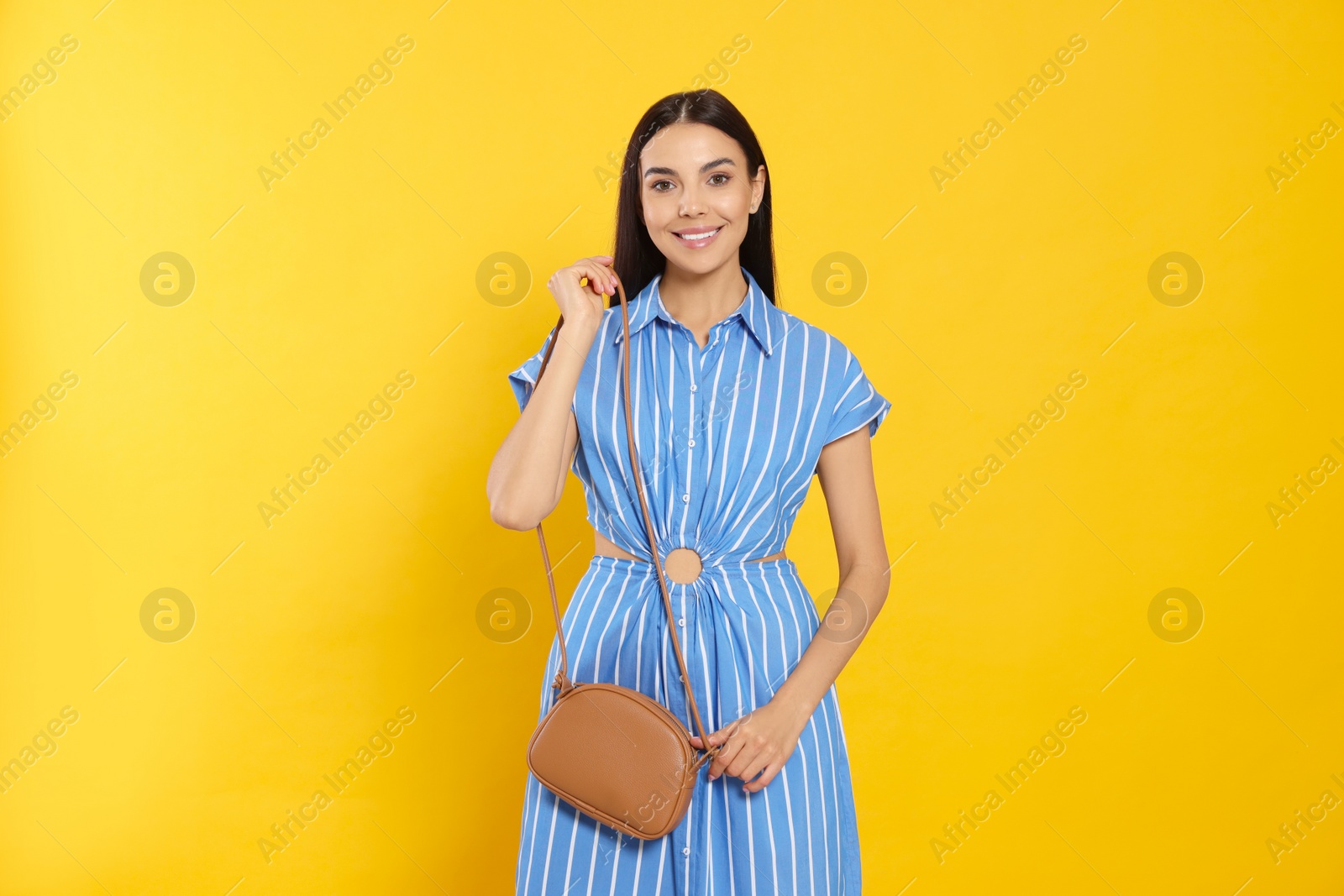 Photo of Beautiful young woman with stylish bag on orange background