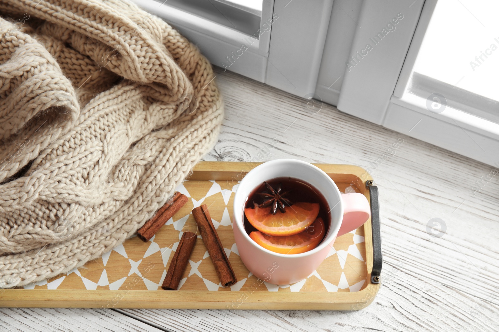 Photo of Composition with cup of hot winter drink on sill near window. Cozy season