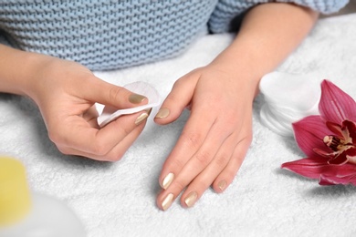 Photo of Woman removing nail polish on towel, closeup