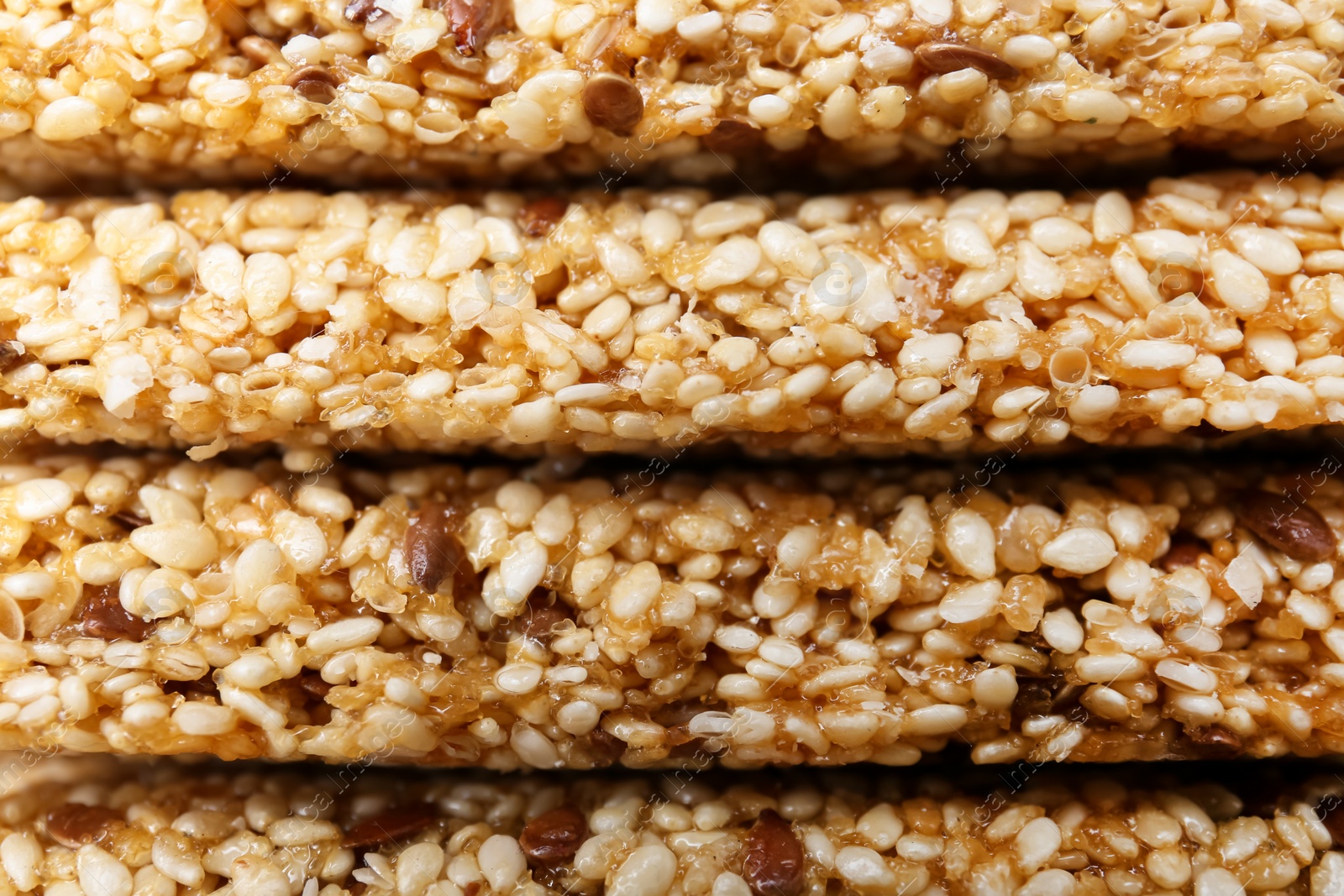Photo of Tasty sesame seed bars as background, closeup