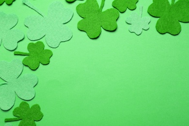Photo of Decorative clover leaves on green background, flat lay with space for text. St. Patrick's Day celebration