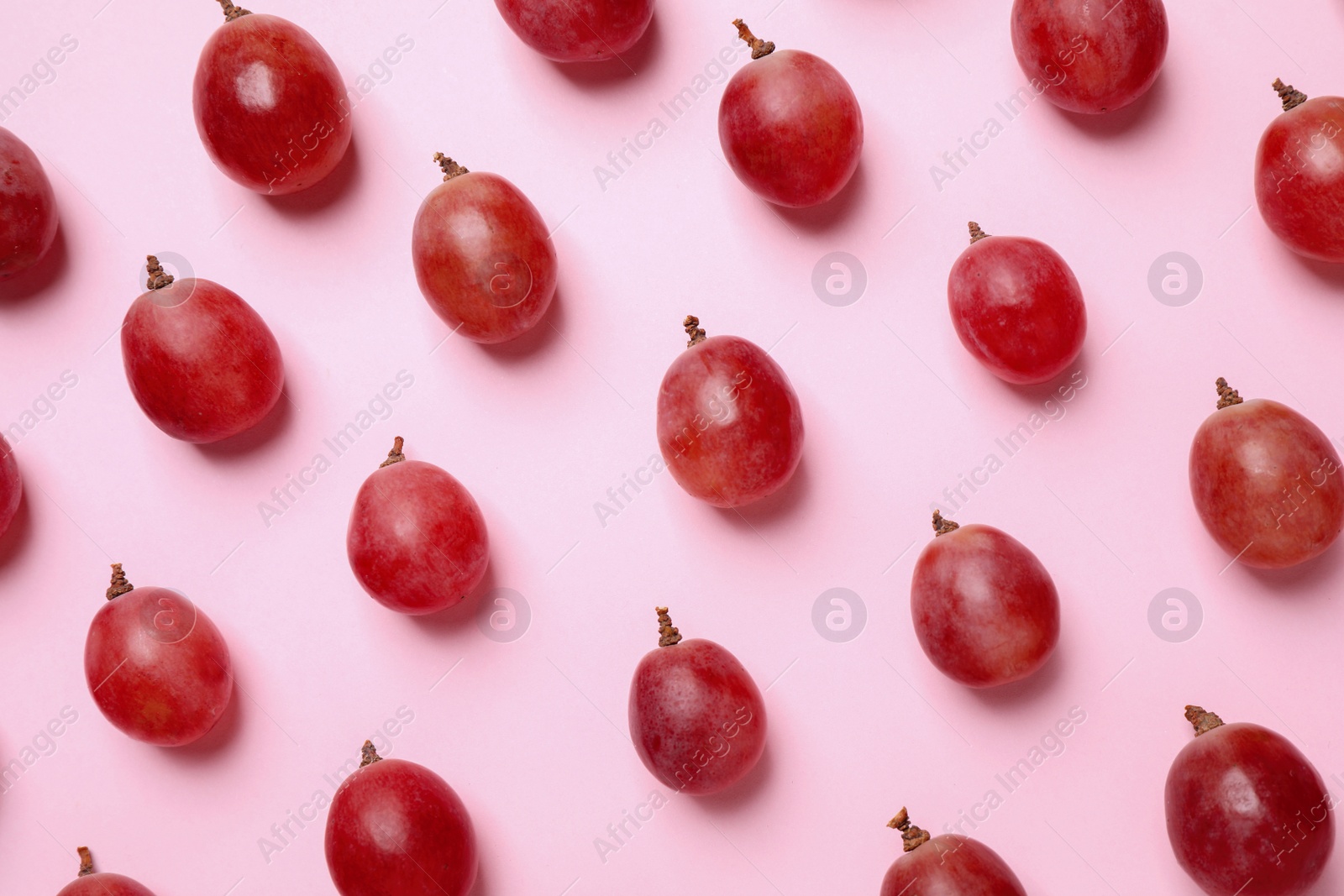 Photo of Flat lay composition with fresh ripe grapes on pink background