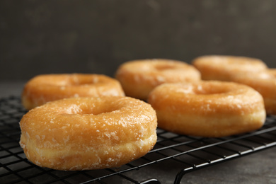 Photo of Sweet delicious glazed donuts on grey table