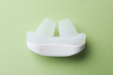 Anti-snoring device for nose on light green background, top view