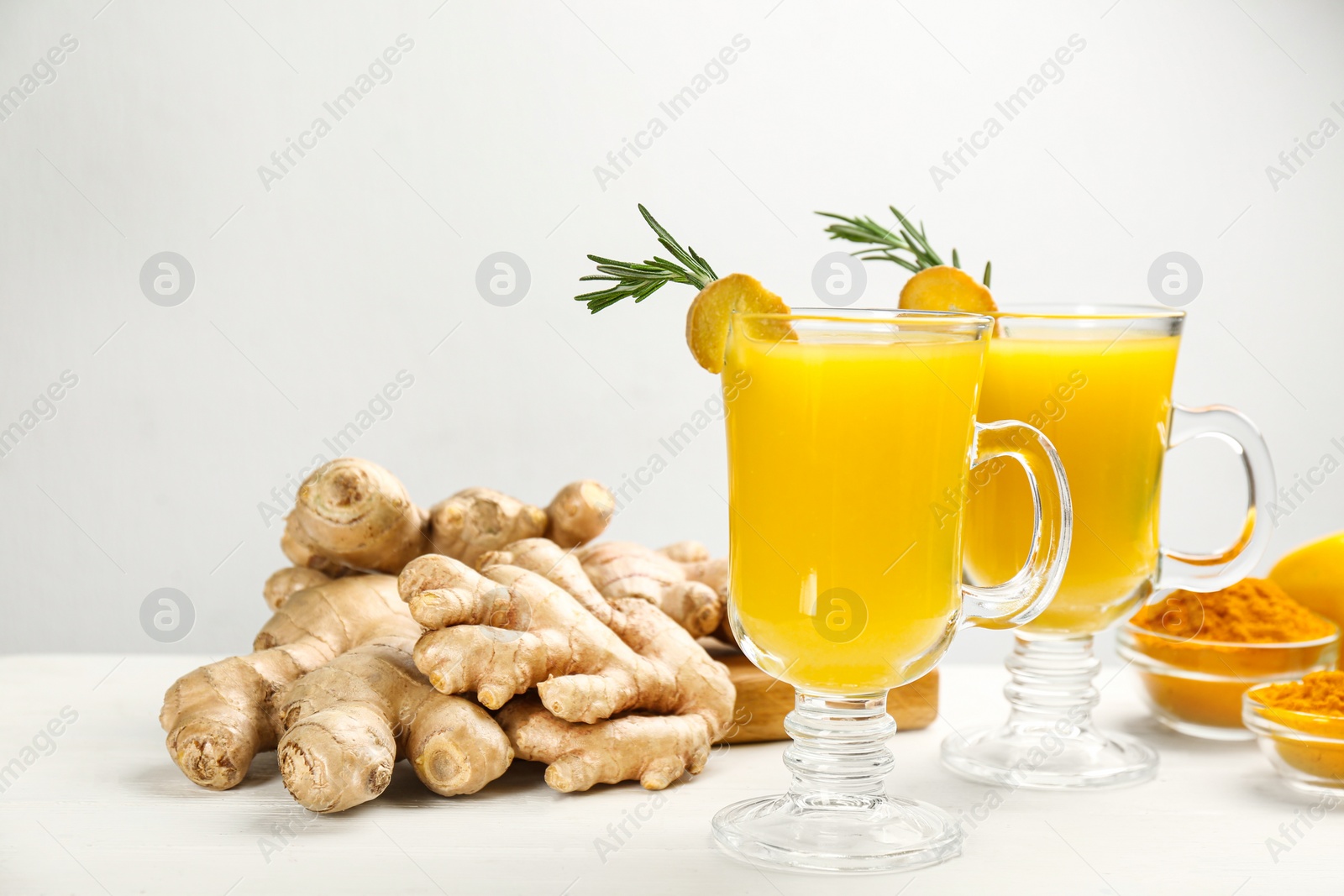 Photo of Immunity boosting drink and ingredients on white wooden table. Space for text