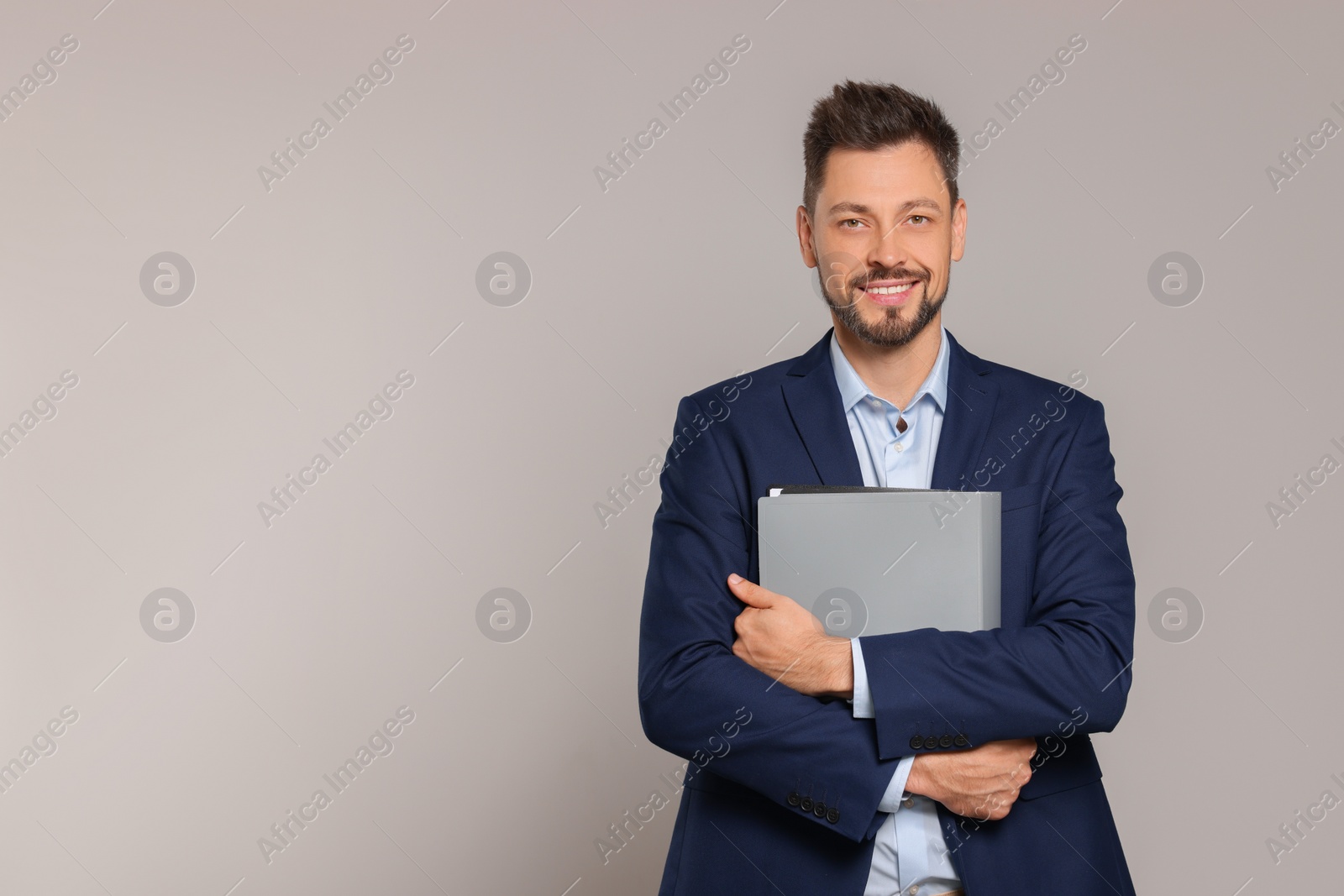 Photo of Happy teacher with stationery against beige background. Space for text