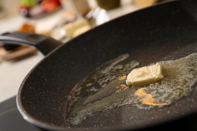 Photo of Frying pan with melted butter on stove, closeup