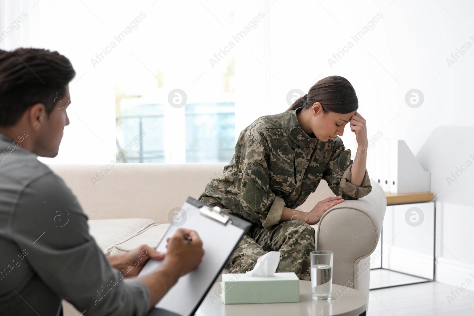 Photo of Psychotherapist working with female military officer in office