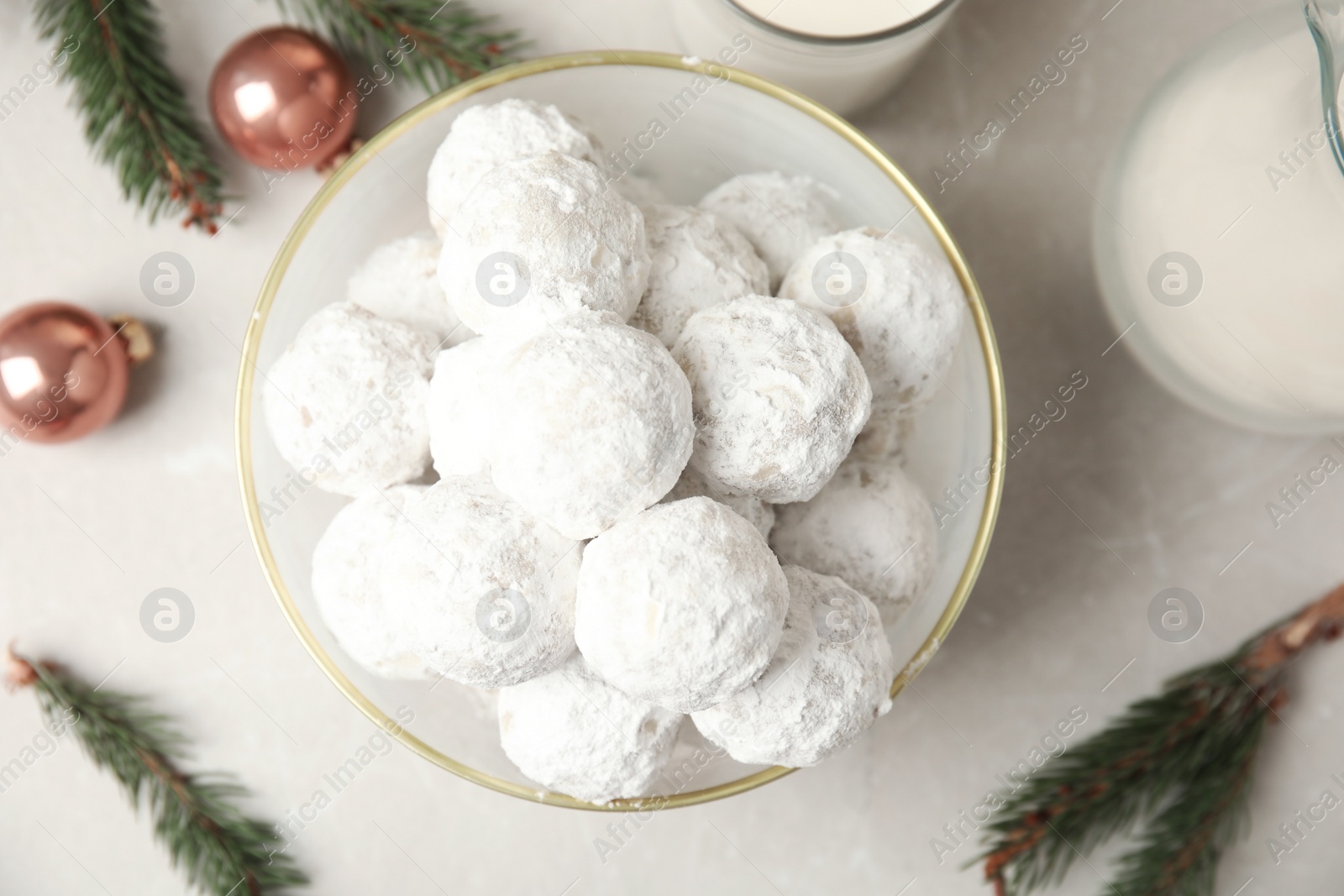 Photo of Tasty snowball cookies in bowl on light table, flat lay. Christmas treat