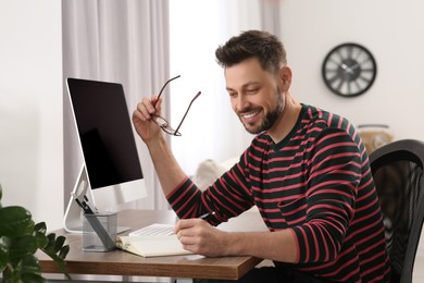 Photo of Man studying near computer at home. Online translation course