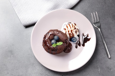 Photo of Plate of delicious fresh fondant with hot chocolate and blueberries on table, top view. Lava cake recipe