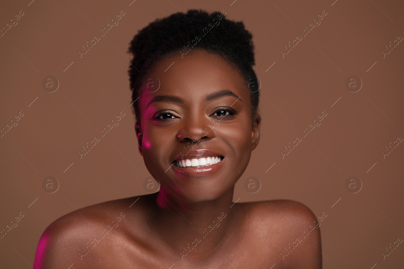 Photo of Fashionable portrait of beautiful happy woman on light brown background