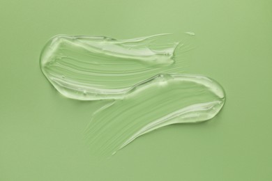 Photo of Sample of clear cosmetic gel on light green background, top view