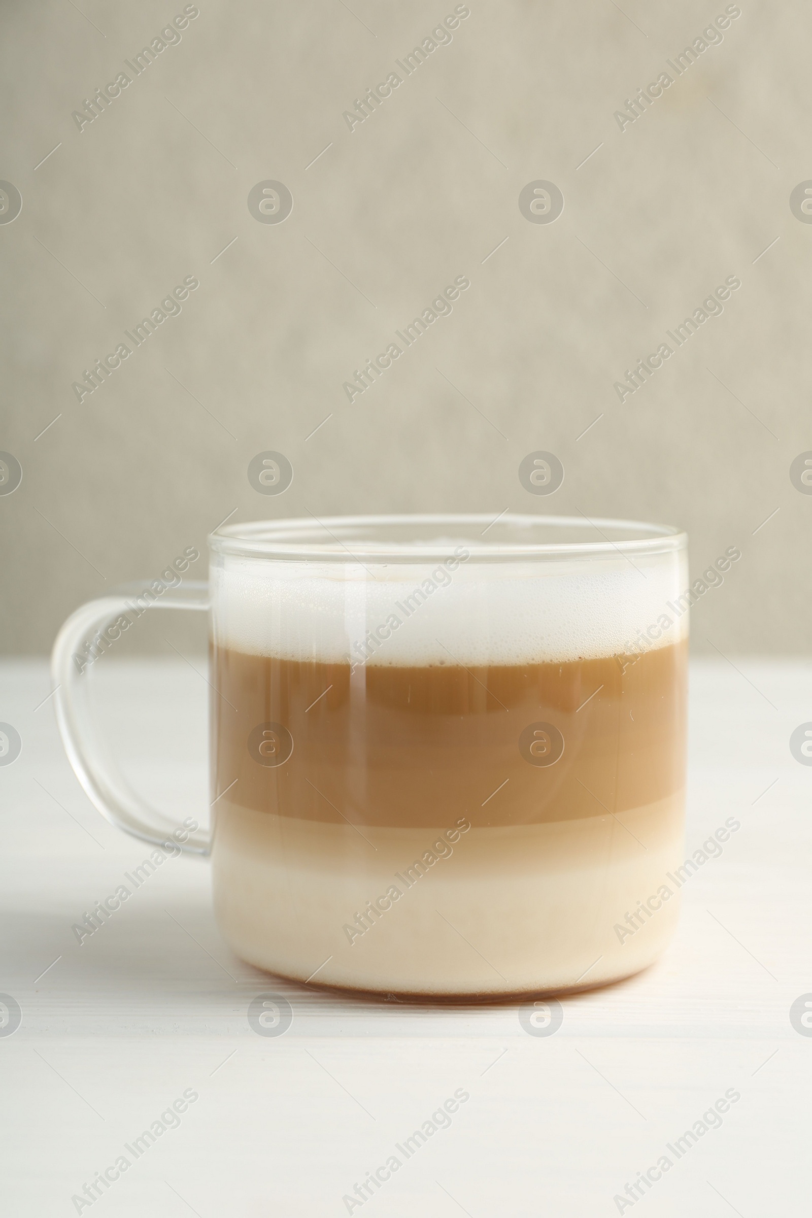 Photo of Aromatic coffee in glass cup on white wooden table