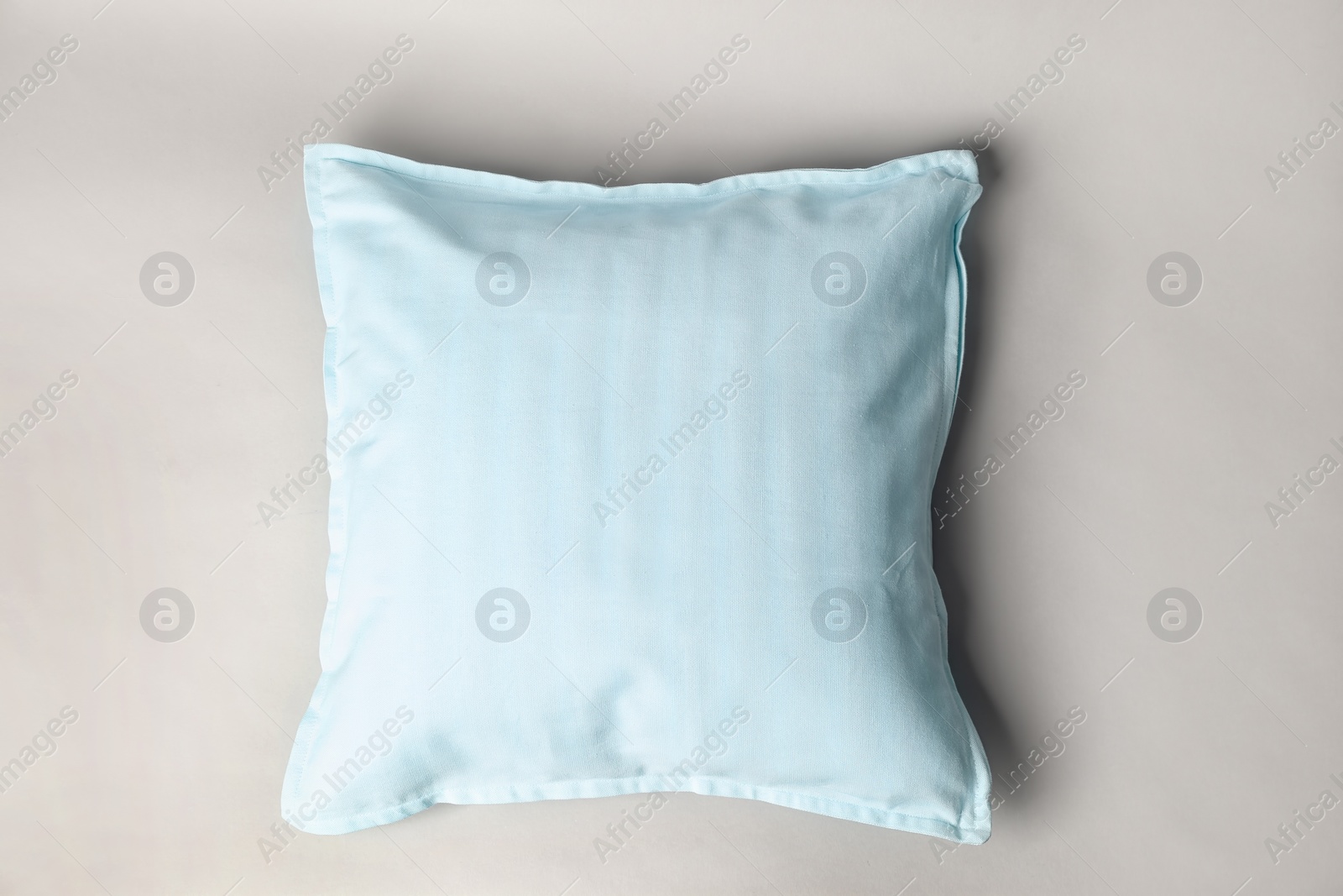 Photo of Soft decorative pillow on light background