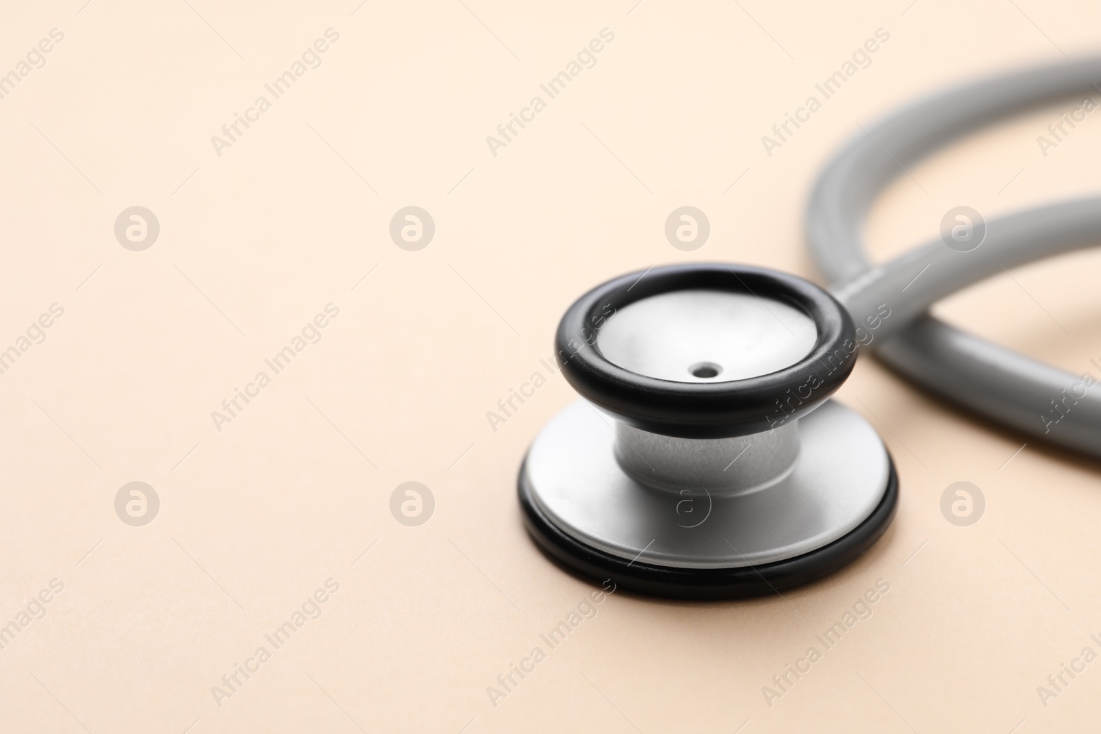 Photo of Stethoscope on beige background, closeup. Space for text