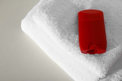 Deodorant with clean towels on light background, above view. Space for text