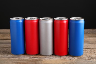 Energy drinks in colorful cans on wooden table
