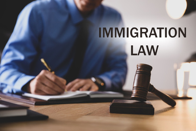 Image of Man working at table in office, focus on gavel. Immigration law
