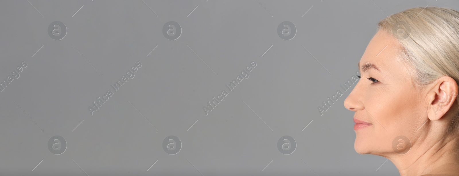 Image of Portrait of beautiful mature woman on grey background, space for text. Banner design