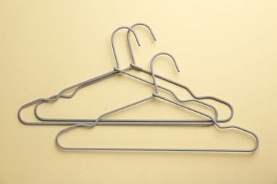 Hangers on pale yellow background, flat lay
