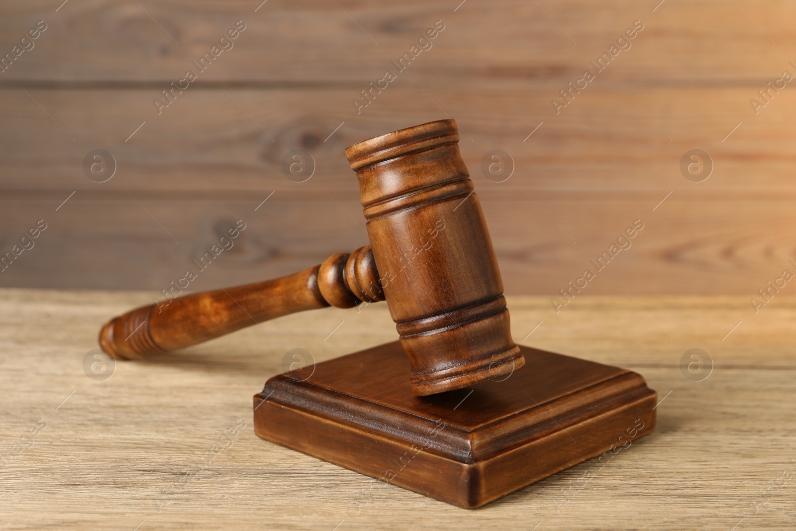 Photo of Wooden gavel and sound block on table, closeup