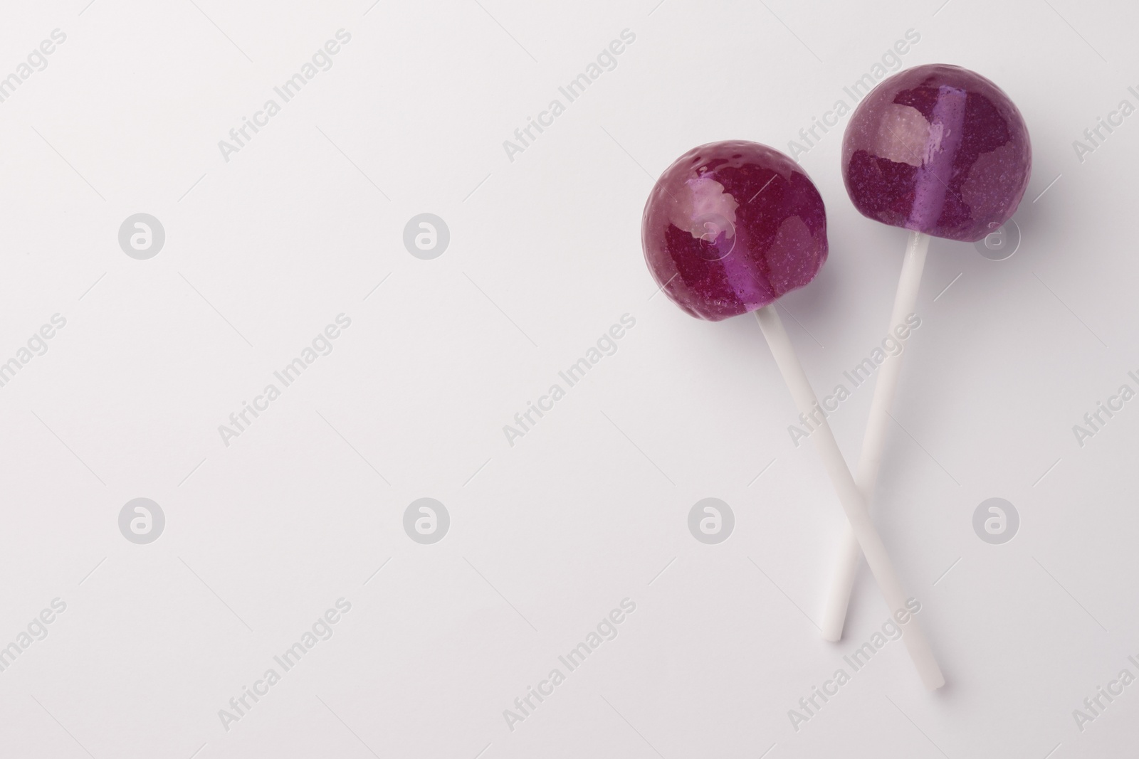 Photo of Tasty lollipops on white background, flat lay. Space for text