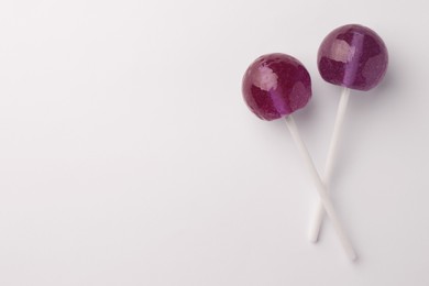 Tasty lollipops on white background, flat lay. Space for text