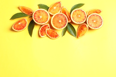 Fresh bloody oranges on color background, flat lay with space for text. Citrus fruits