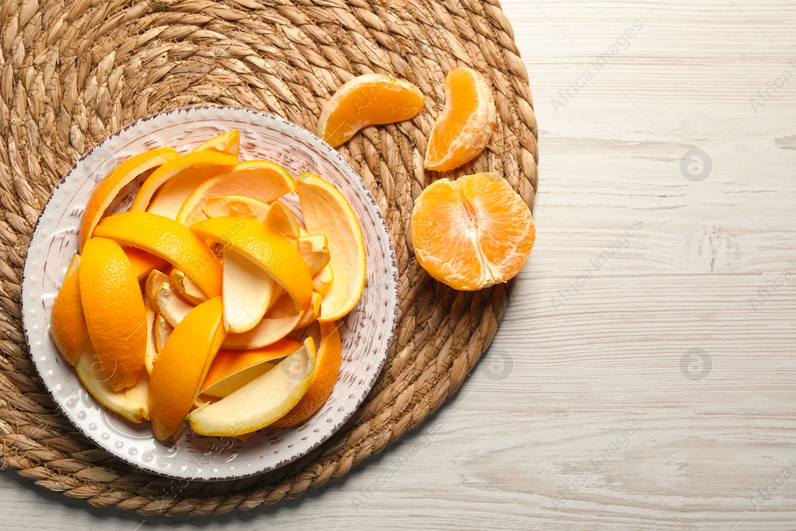 Photo of Orange peels preparing for drying and fresh fruit on white wooden table, top view. Space for text