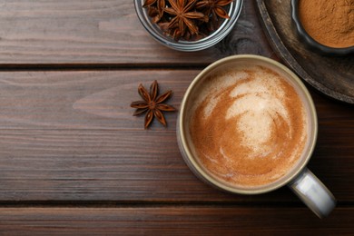 Photo of Cup of delicious eggnog with anise on wooden table, flat lay. Space for text