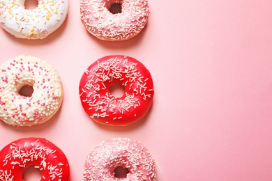 Photo of Delicious glazed doughnuts on color background, top view