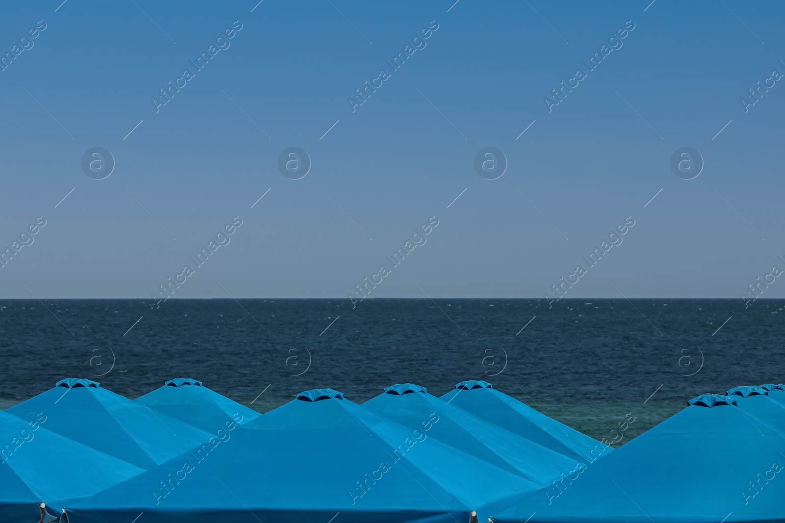 Photo of Many beach umbrellas at resort on sunny day