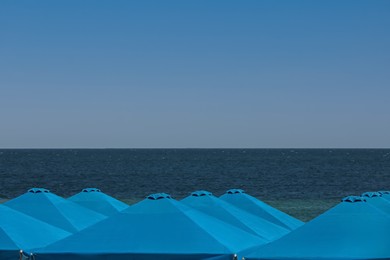 Many beach umbrellas at resort on sunny day