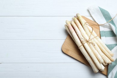 Photo of Fresh white asparagus on wooden table, top view. Space for text