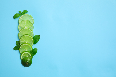 Photo of Slices of fresh juicy lime and mint on blue background, flat lay. Space for text