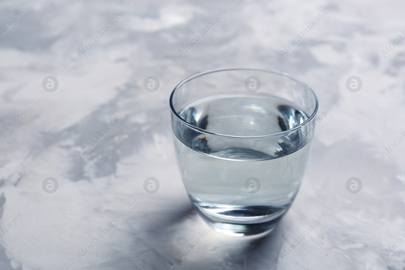 Photo of Glass with fresh water on table. Space for text