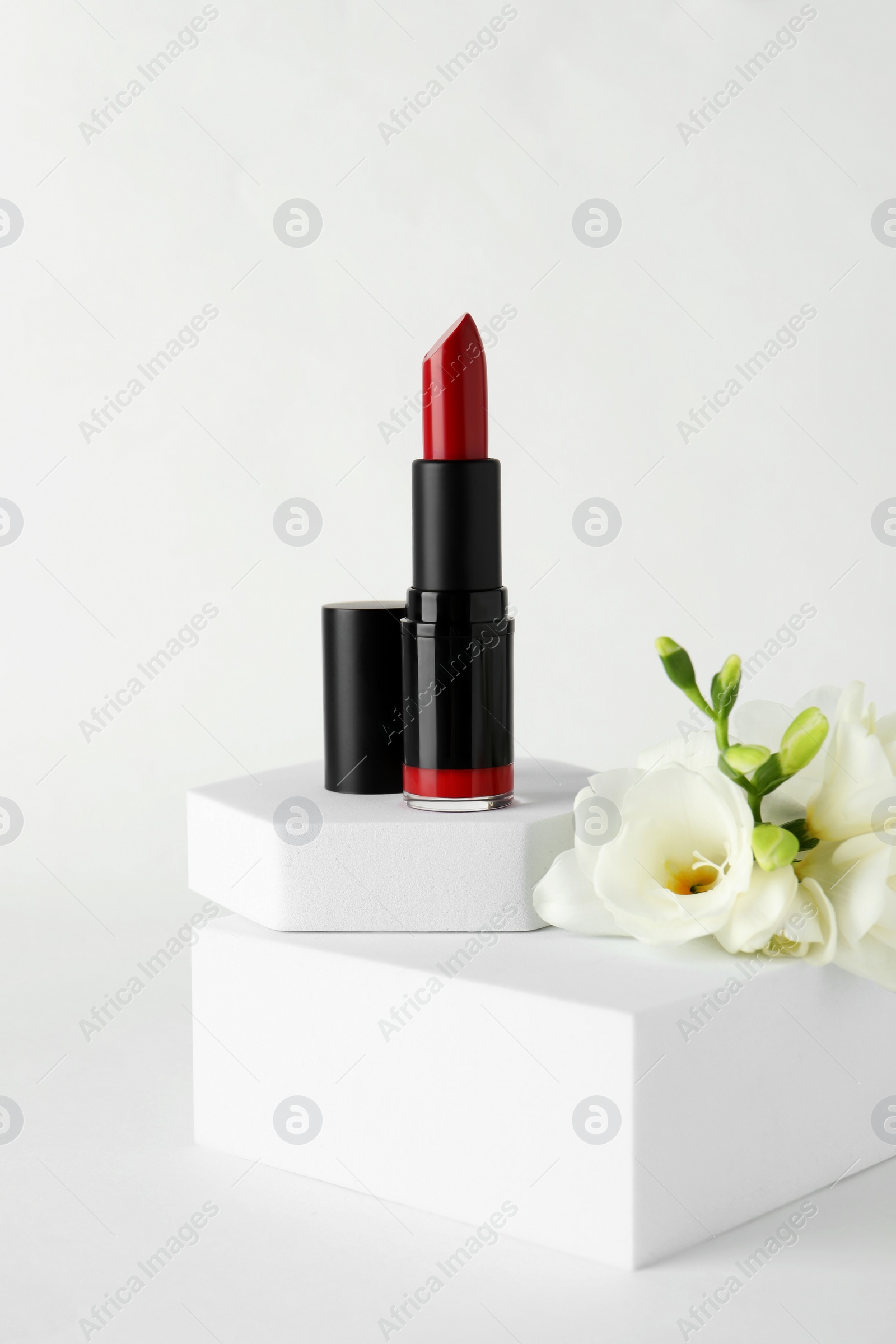 Photo of Beautiful red lipstick and eustoma flowers on white background