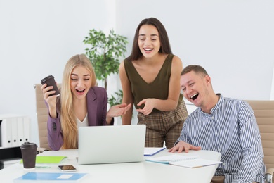 Group of colleagues laughing together in office