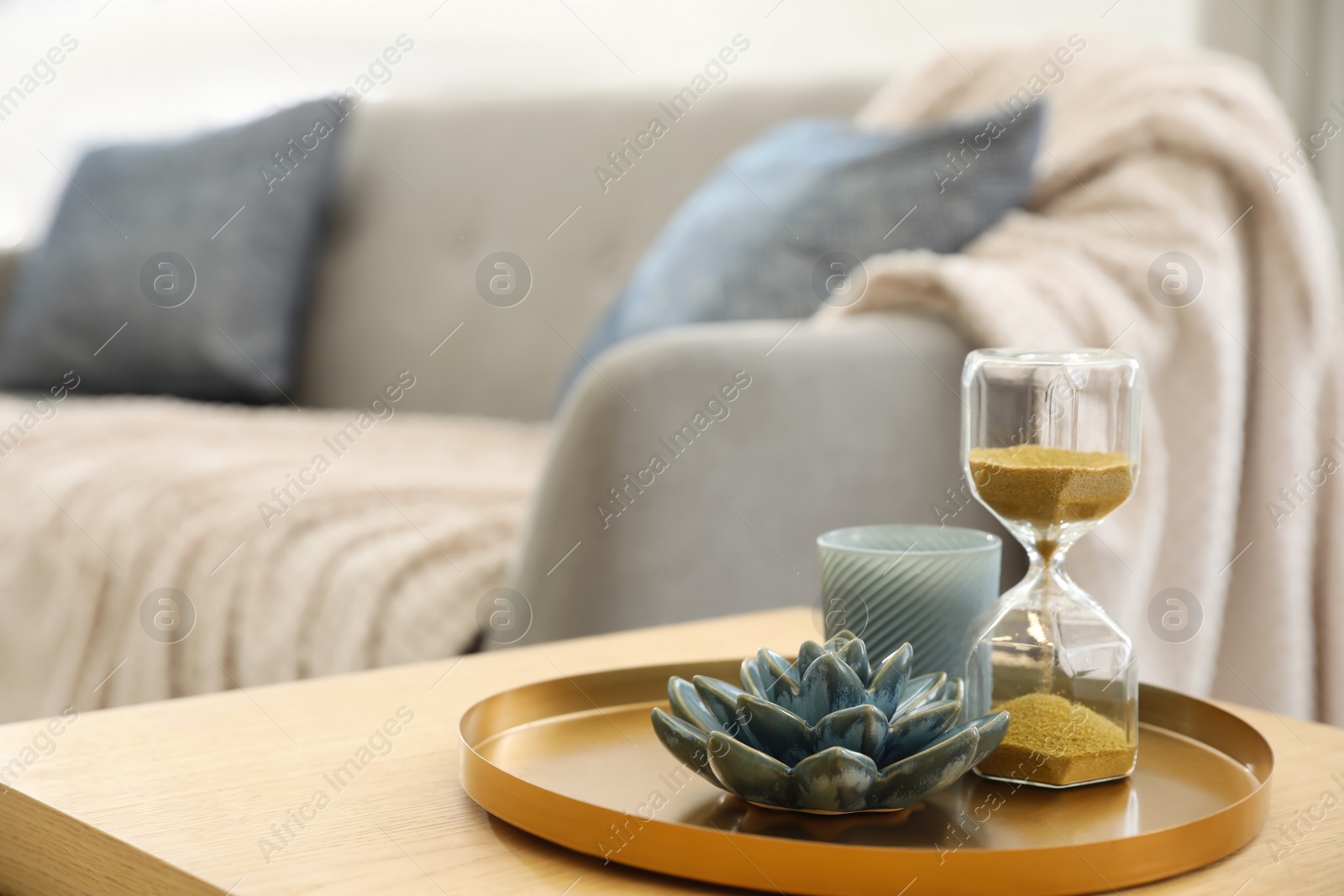 Photo of Table with decor near sofa indoors. Interior design