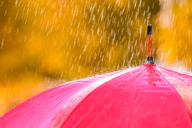 Photo of Bright color umbrella under rain outdoors, closeup