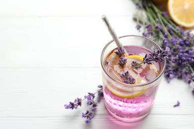 Photo of Fresh delicious lemonade with lavender on white wooden table. Space for text