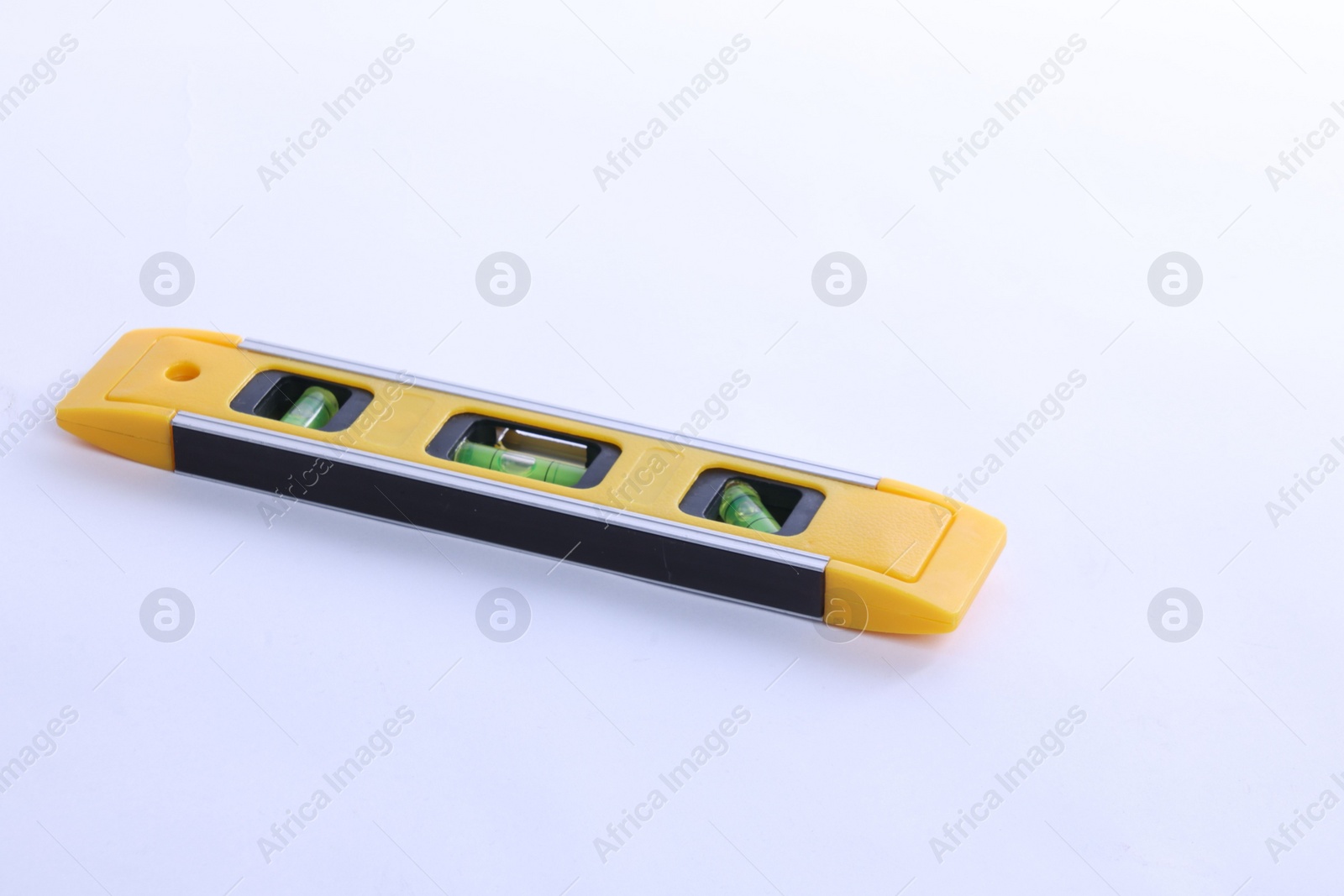 Photo of Yellow building level on white background. Construction tool