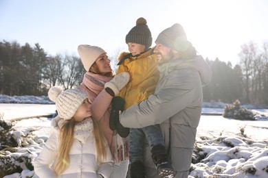Photo of Happy family spending time together in sunny snowy park